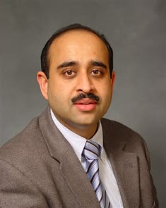 Dr. Ravinder Singh wear brown coat and white shirt and tie