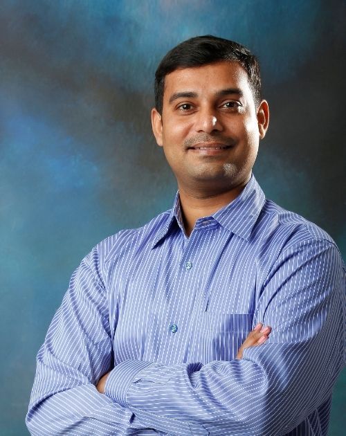 Dr Rajesh Sharma Wear Blue shirt and hand fold and smile